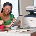 Deux femmes utilisant une tablette devant une imprimante multifonction Xerox® VersaLink® B415
