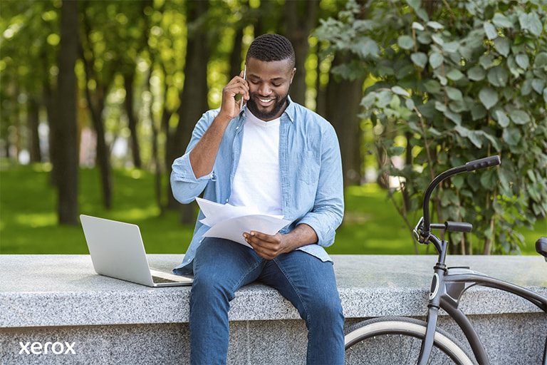 Un homme est assis sur un banc, utilisant son ordinateur portable, tandis que son vélo est garé à côté de lui dans un environnement paisible. Un homme est assis sur un banc, utilisant son ordinateur portable, tandis que son vélo est garé à côté de lui dans un environnement paisible.
